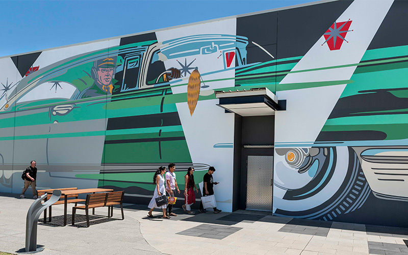Shoppers passing mural at Dunreath Village shopping centre, Perth Airport