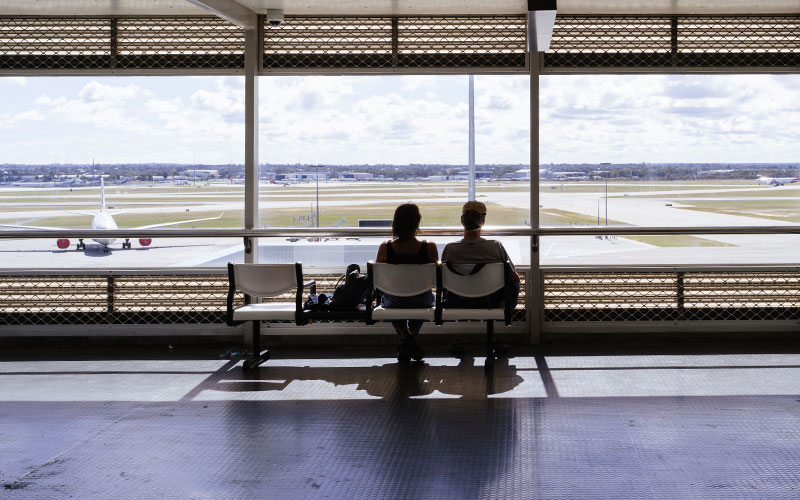 Window looking out to aircraft with passengers walking infront